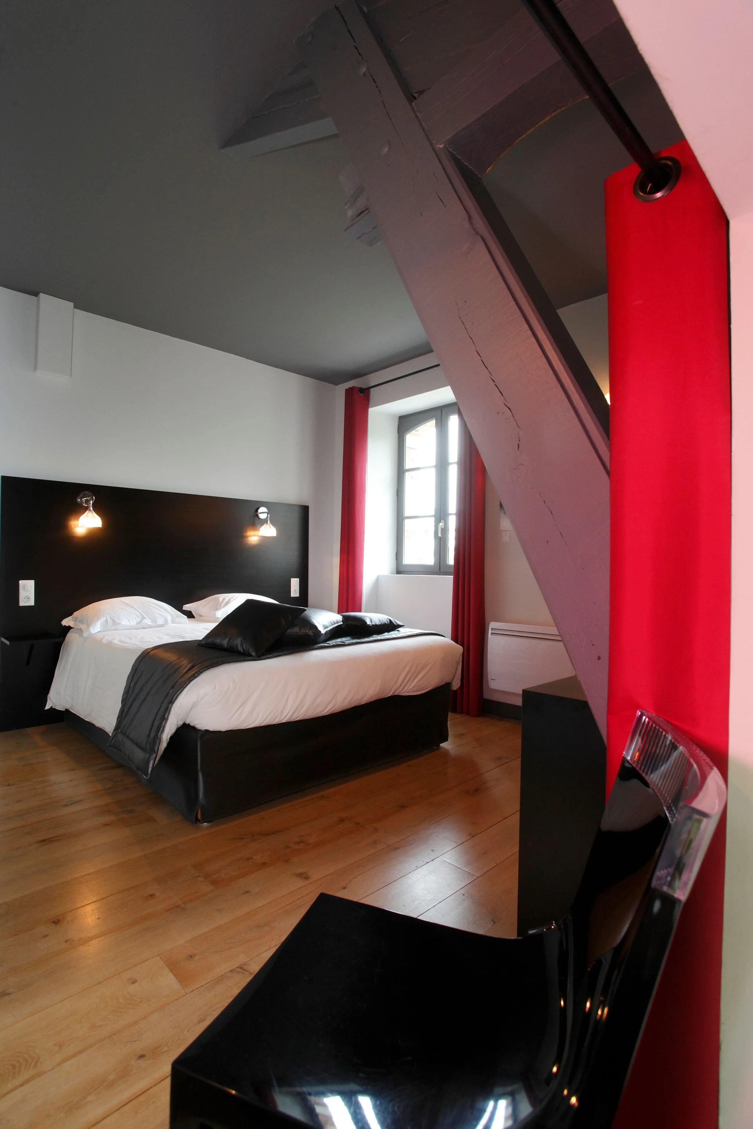 Chambre moderne avec lit double et poutre apparente