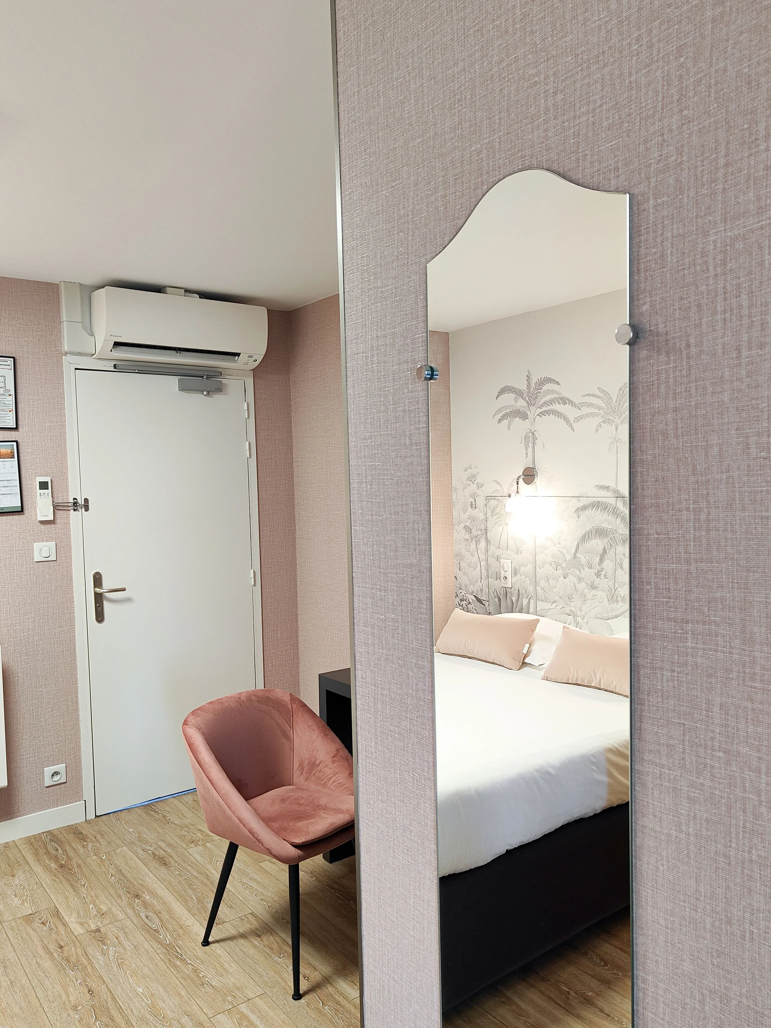 Chambre moderne avec miroir et fauteuil rose