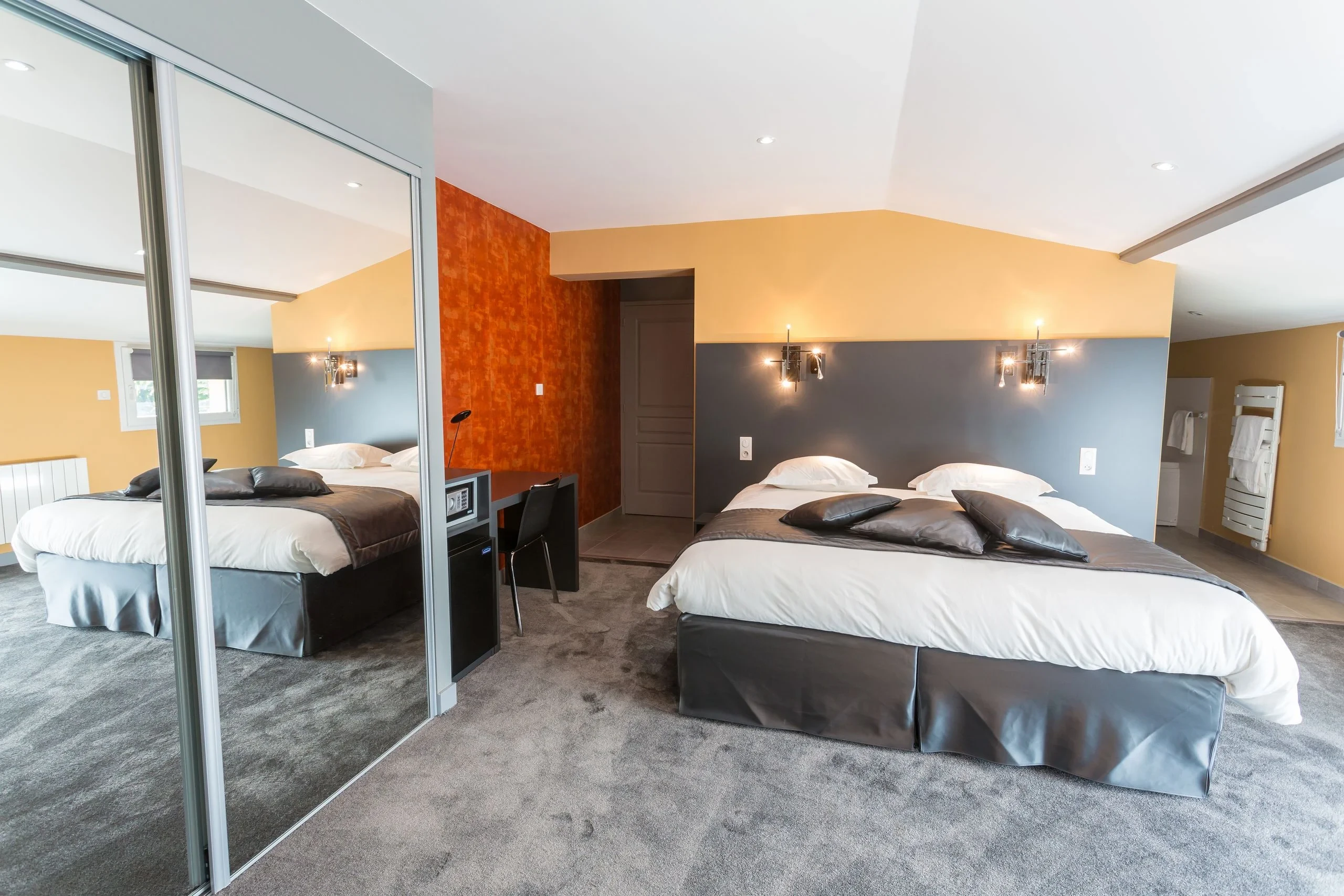 Chambre moderne avec grand lit et armoire miroir