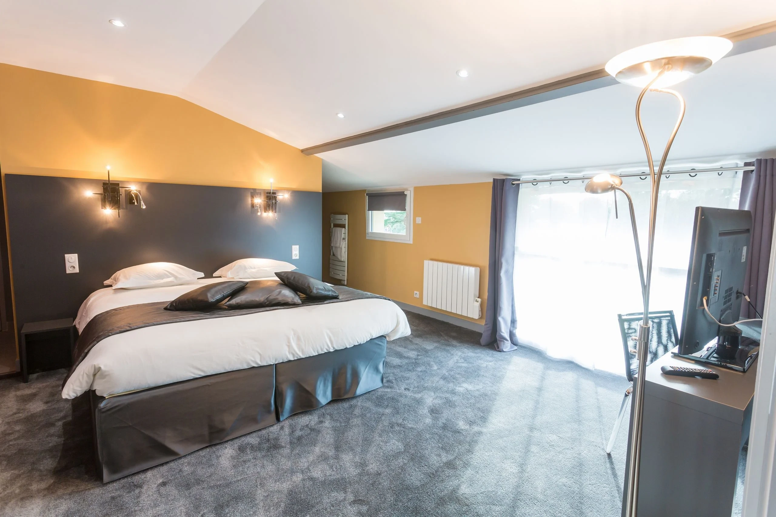 Chambre moderne avec lit double et grande fenêtre