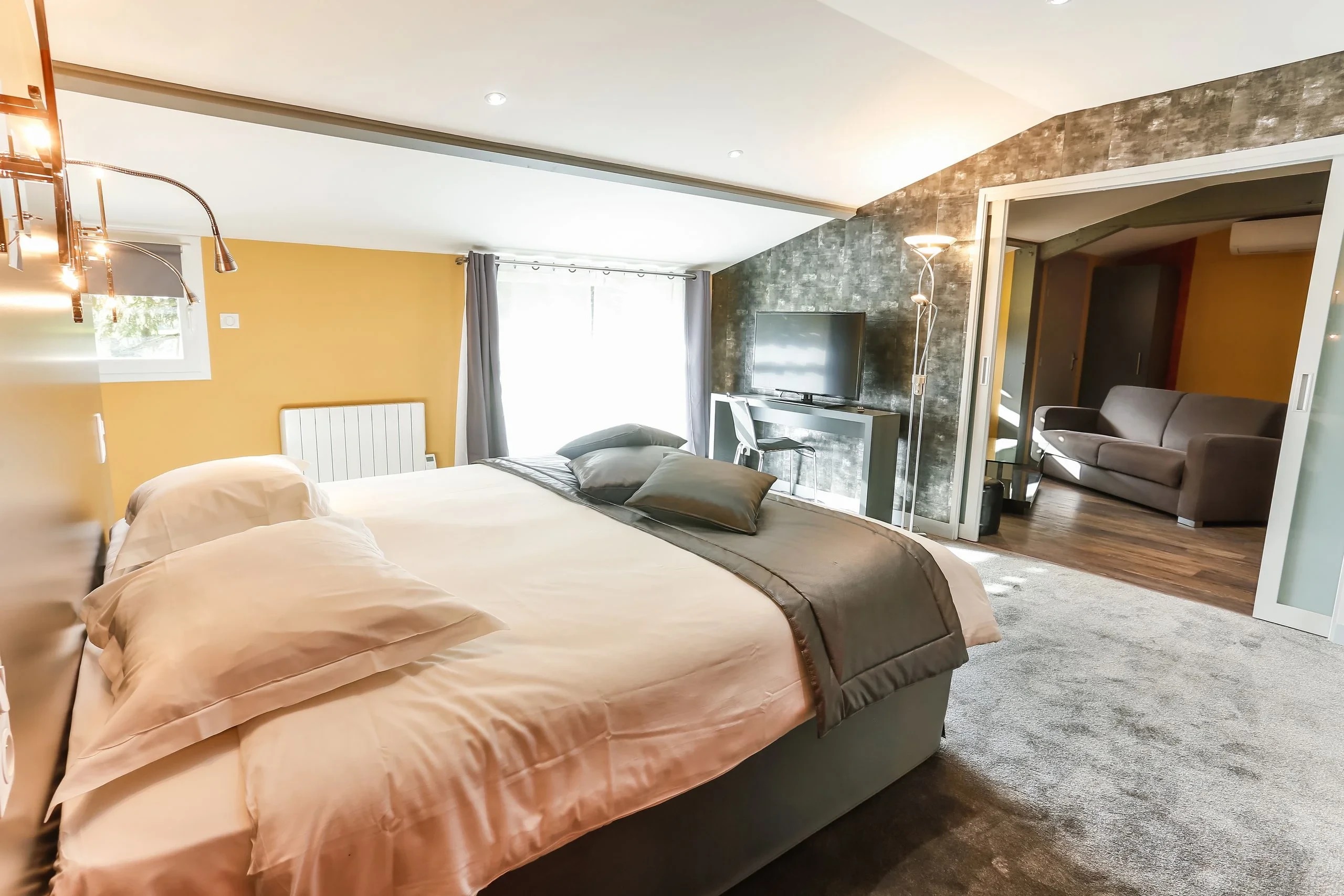 Chambre moderne avec grand lit et télévision