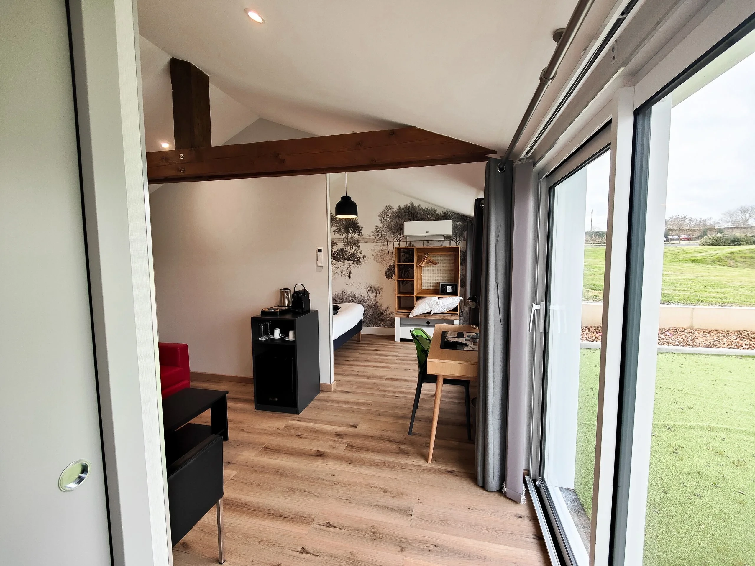 Chambre moderne avec grande baie vitrée et bureau