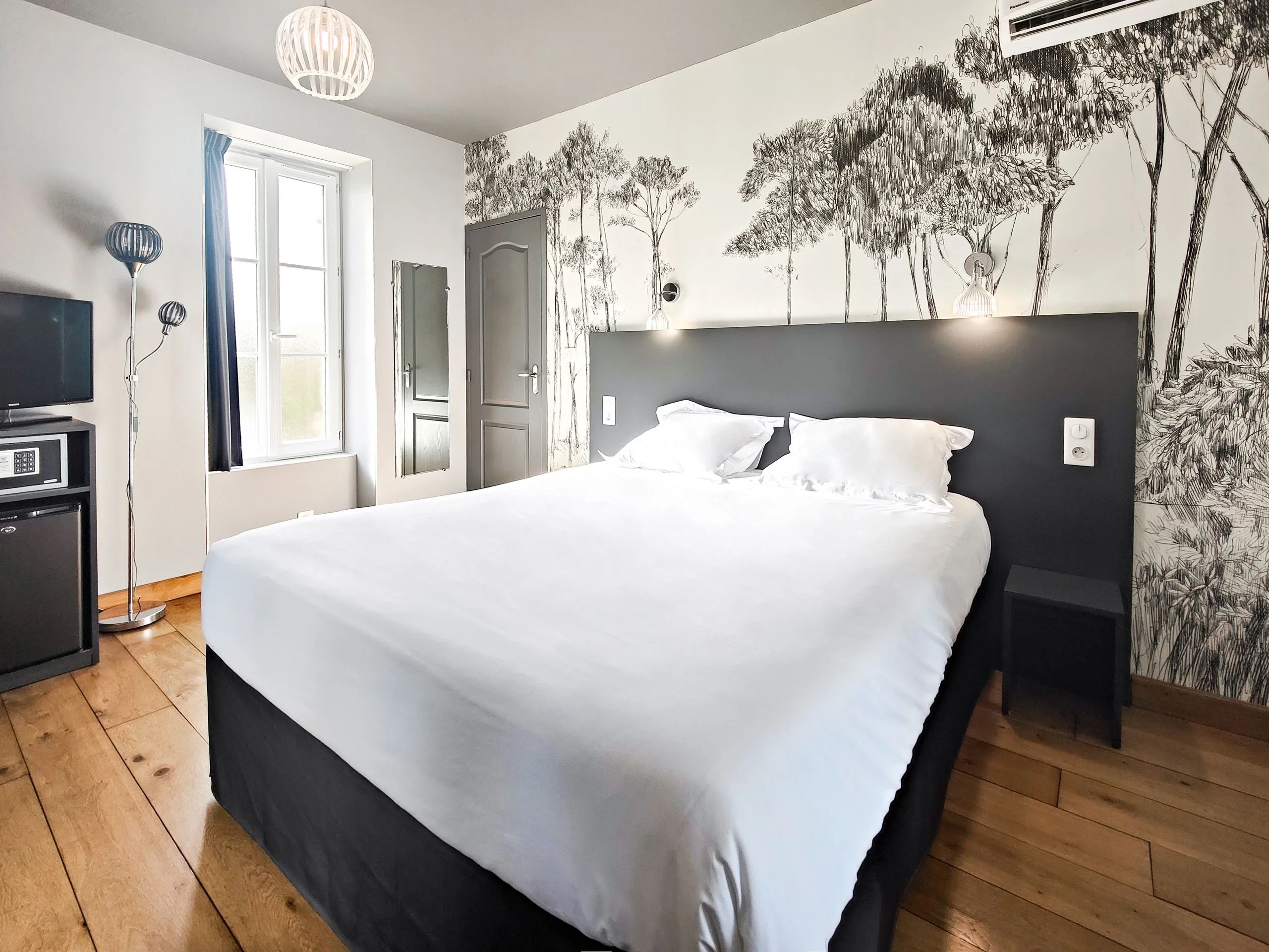 Chambre moderne avec lit double et fresque forestière