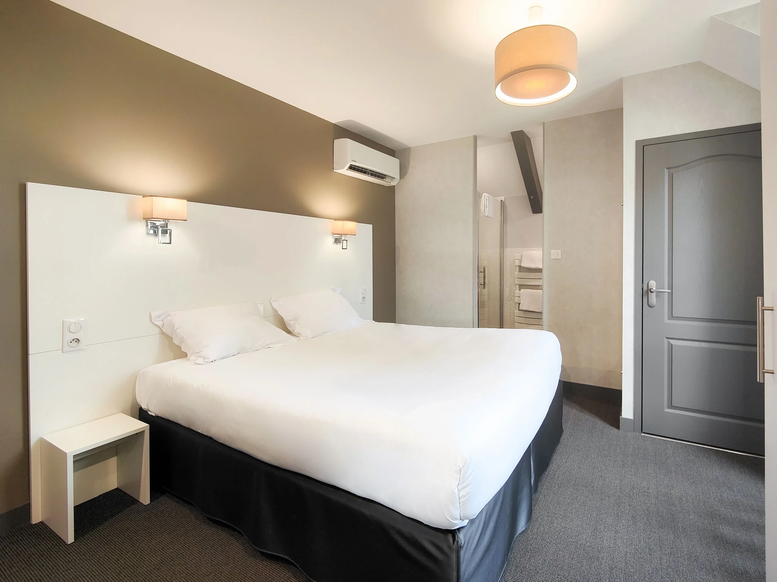Chambre d’hôtel moderne avec lit double et salle d’eau