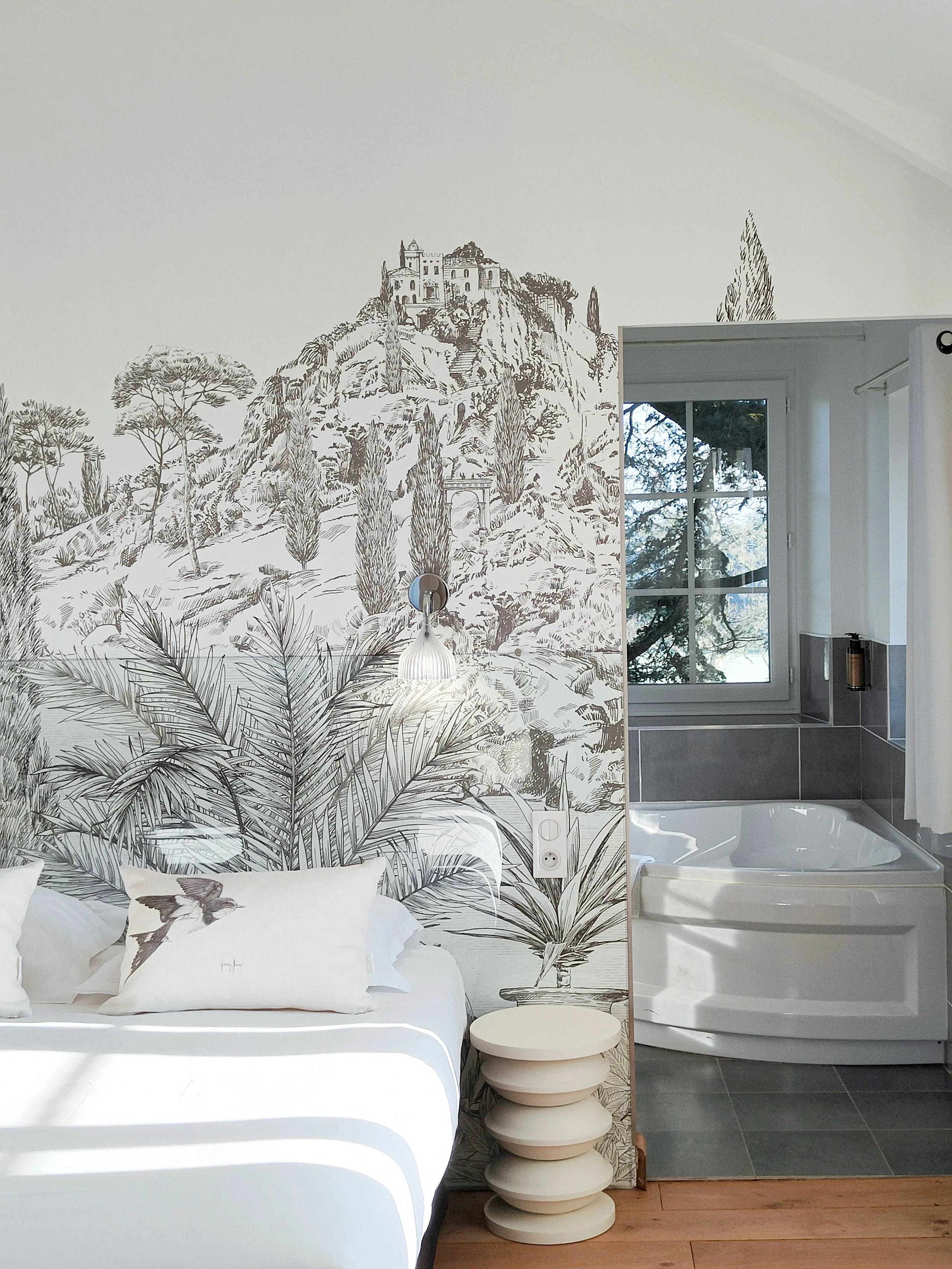 Chambre avec fresque murale et baignoire moderne