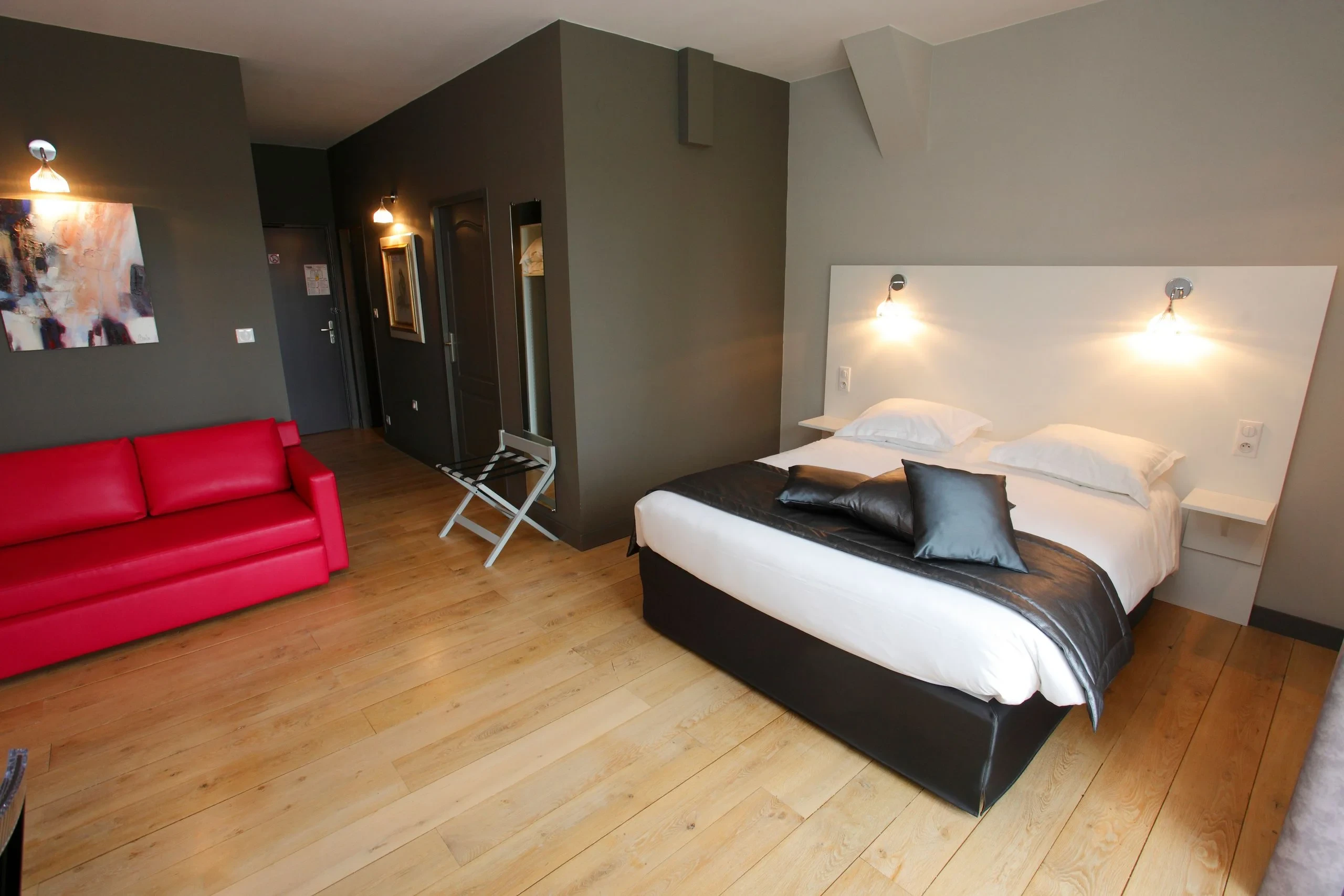 Chambre moderne avec lit double et canapé rouge