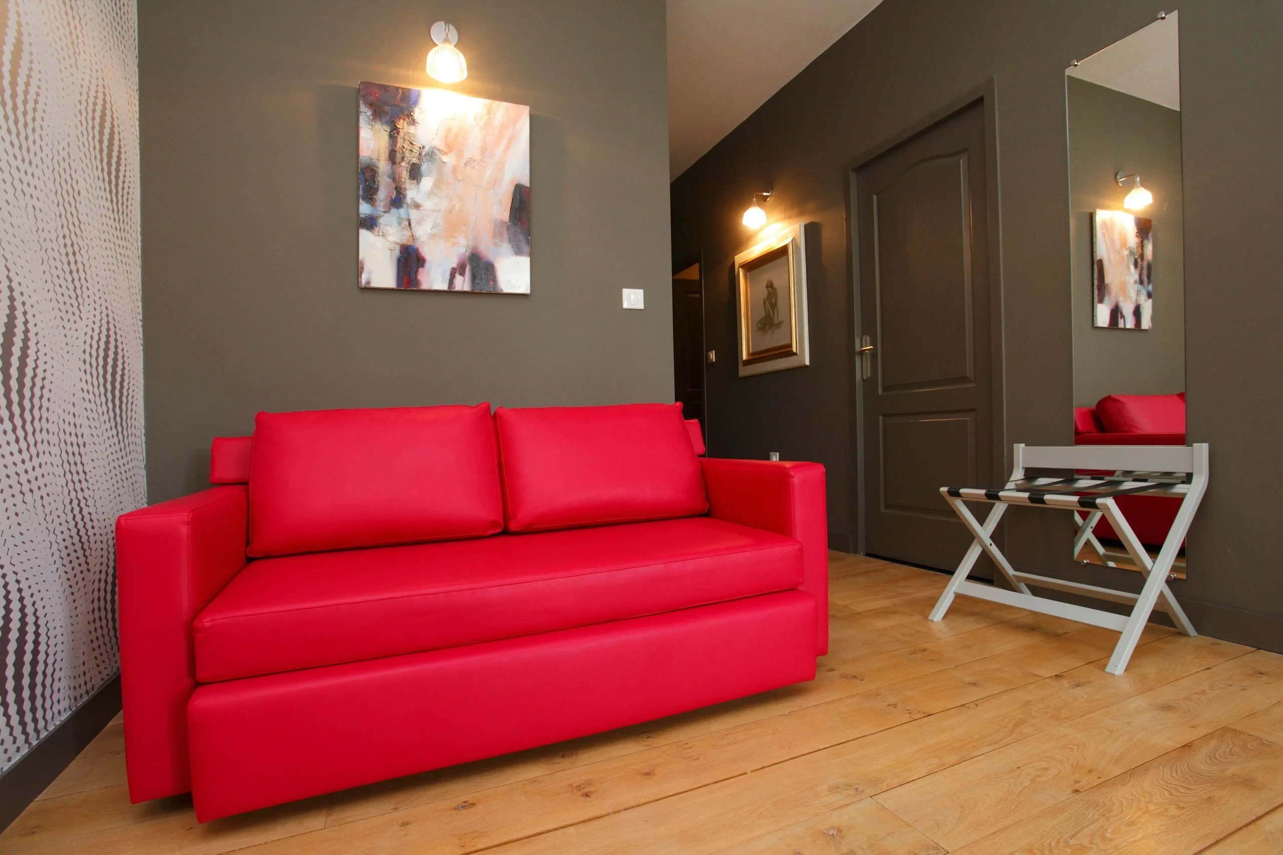 Canapé rouge dans salon moderne aux murs gris
