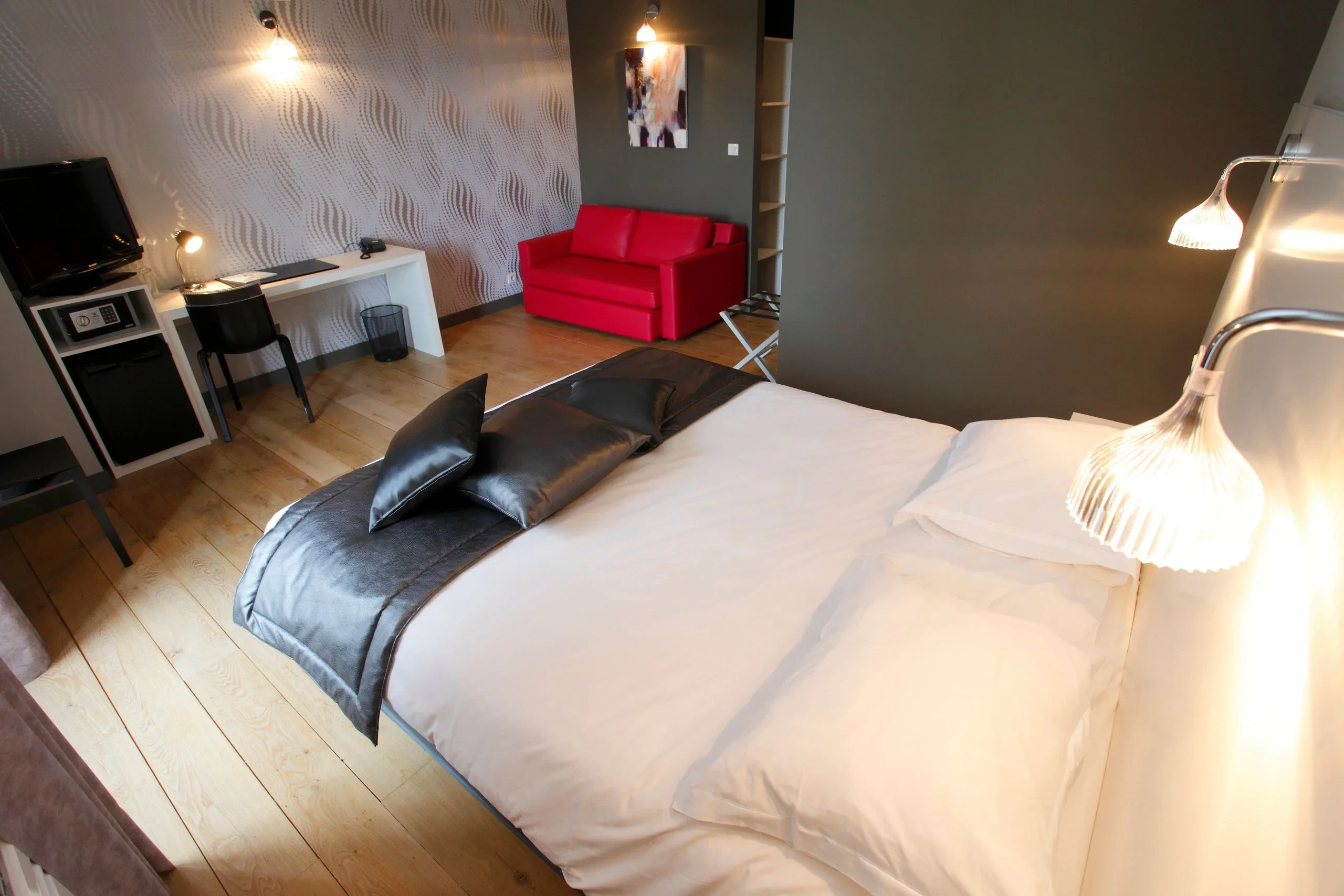 Chambre moderne avec lit double et canapé rouge