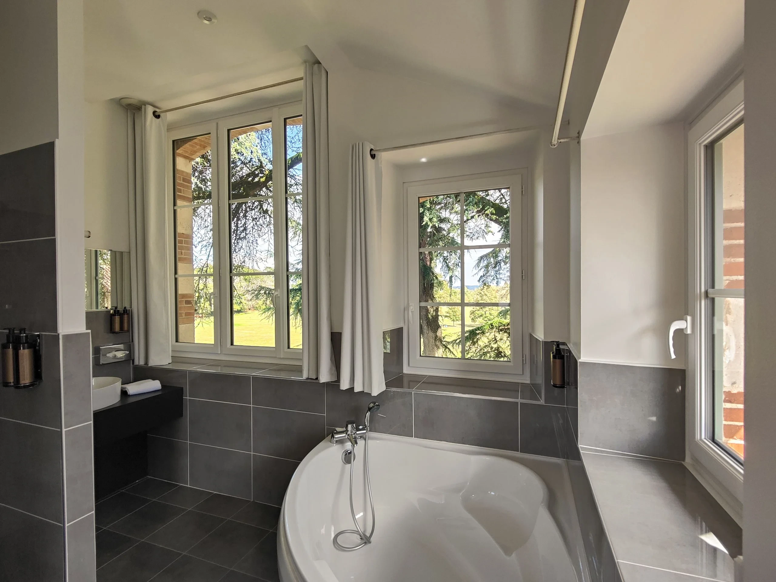 Salle de bain moderne avec baignoire et grandes fenêtres