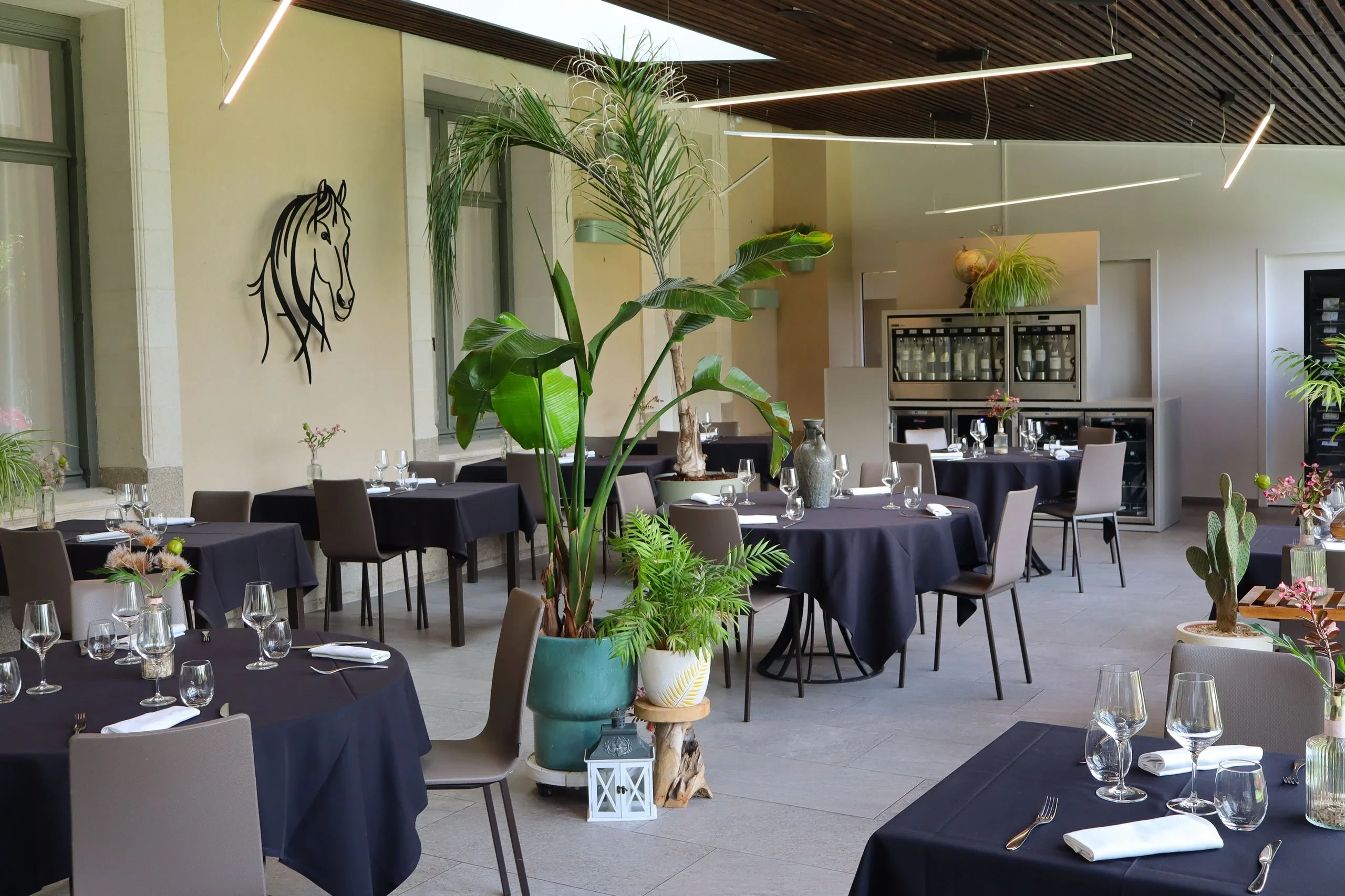 Salle de restaurant élégante avec plantes et tables dressées