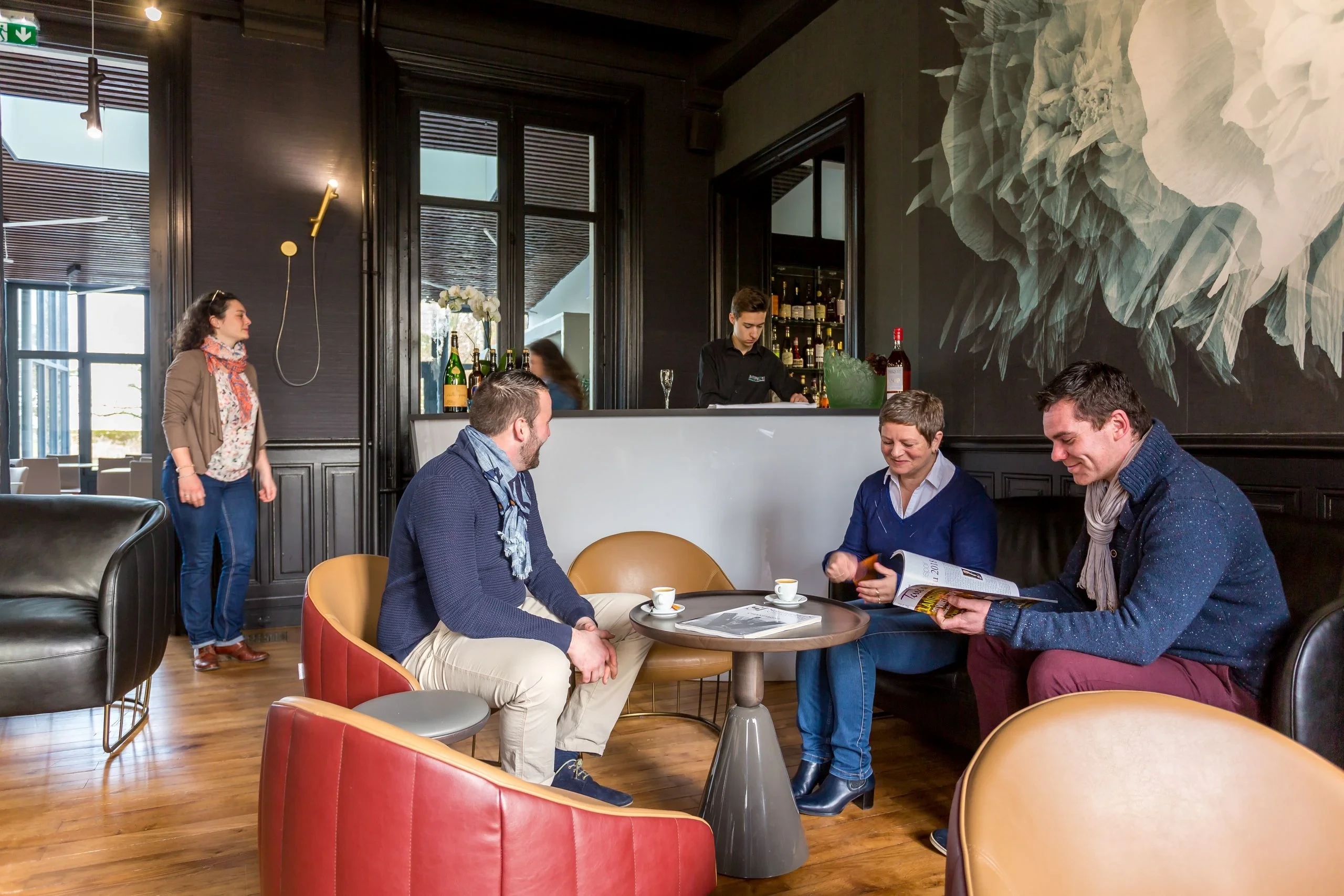 Trois adultes discutant autour d’un café au bar