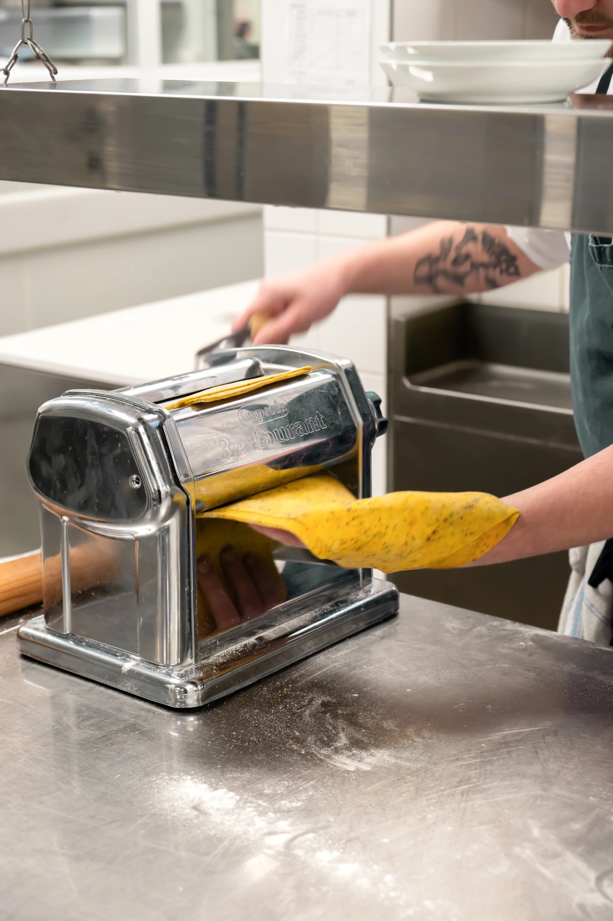 Chef étalant pâte fraîche au laminoir
