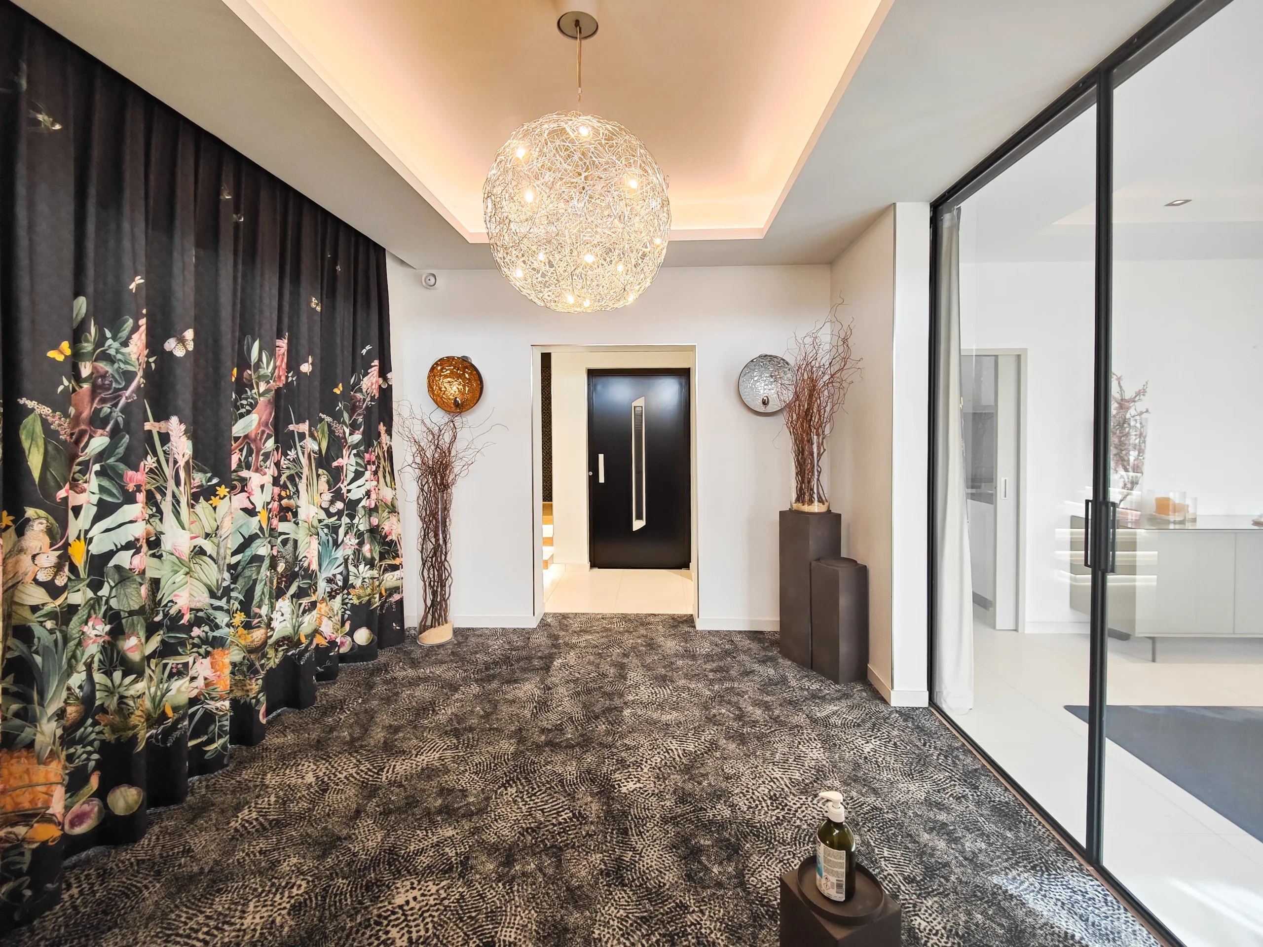 Entrée moderne avec grand lustre et rideaux floraux