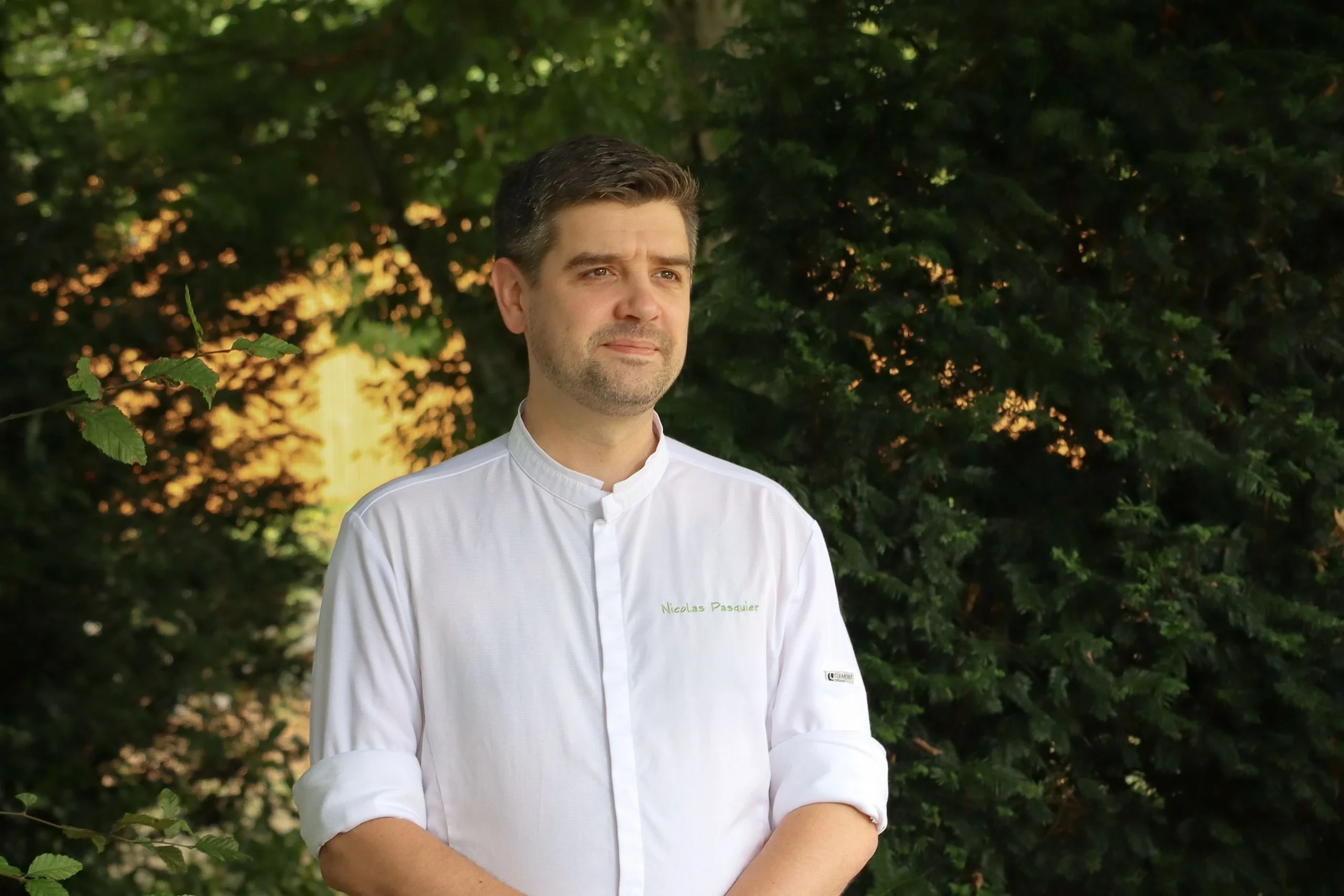 Chef en veste blanche dans un jardin