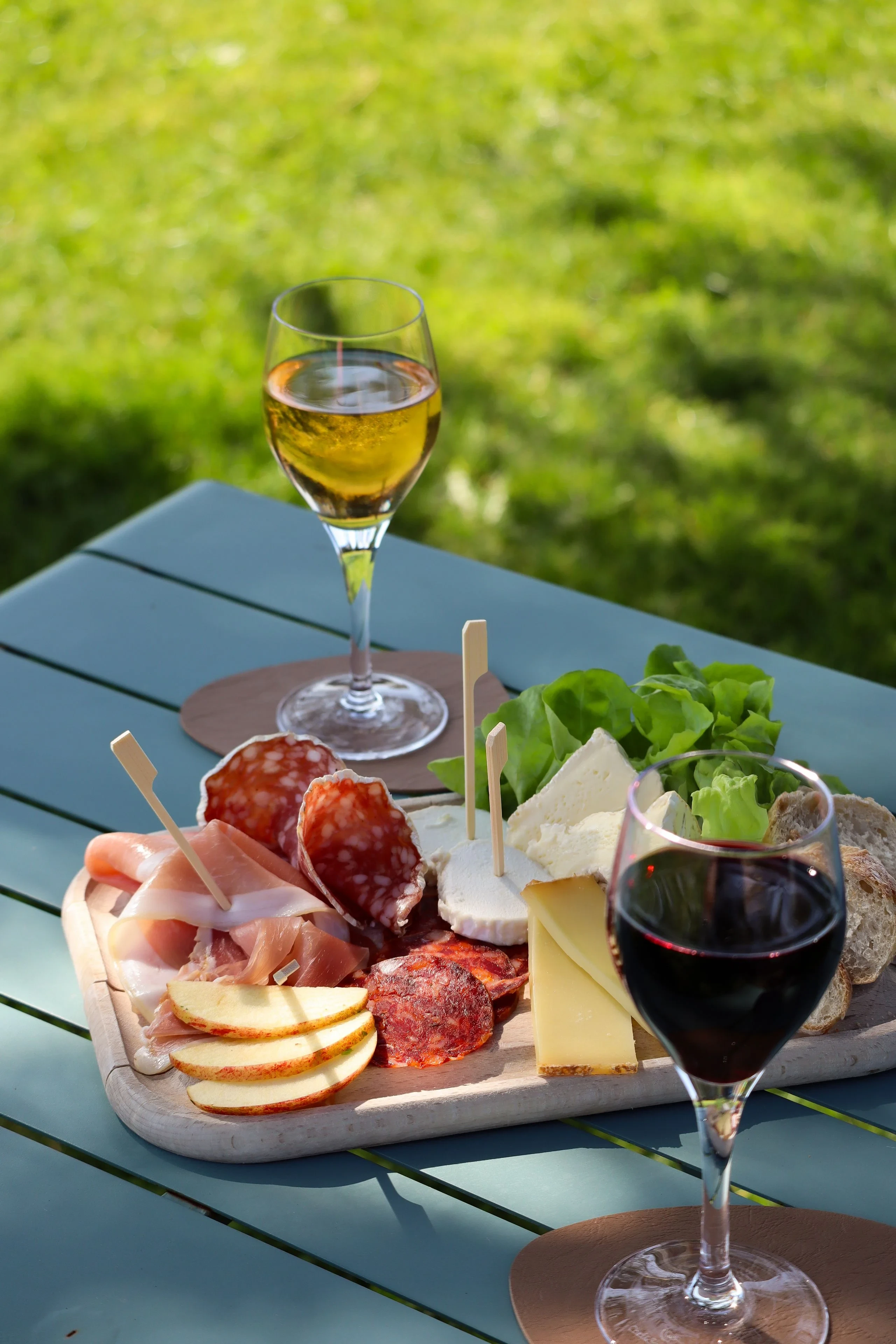 Plateau de charcuterie et verres de vin en extérieur