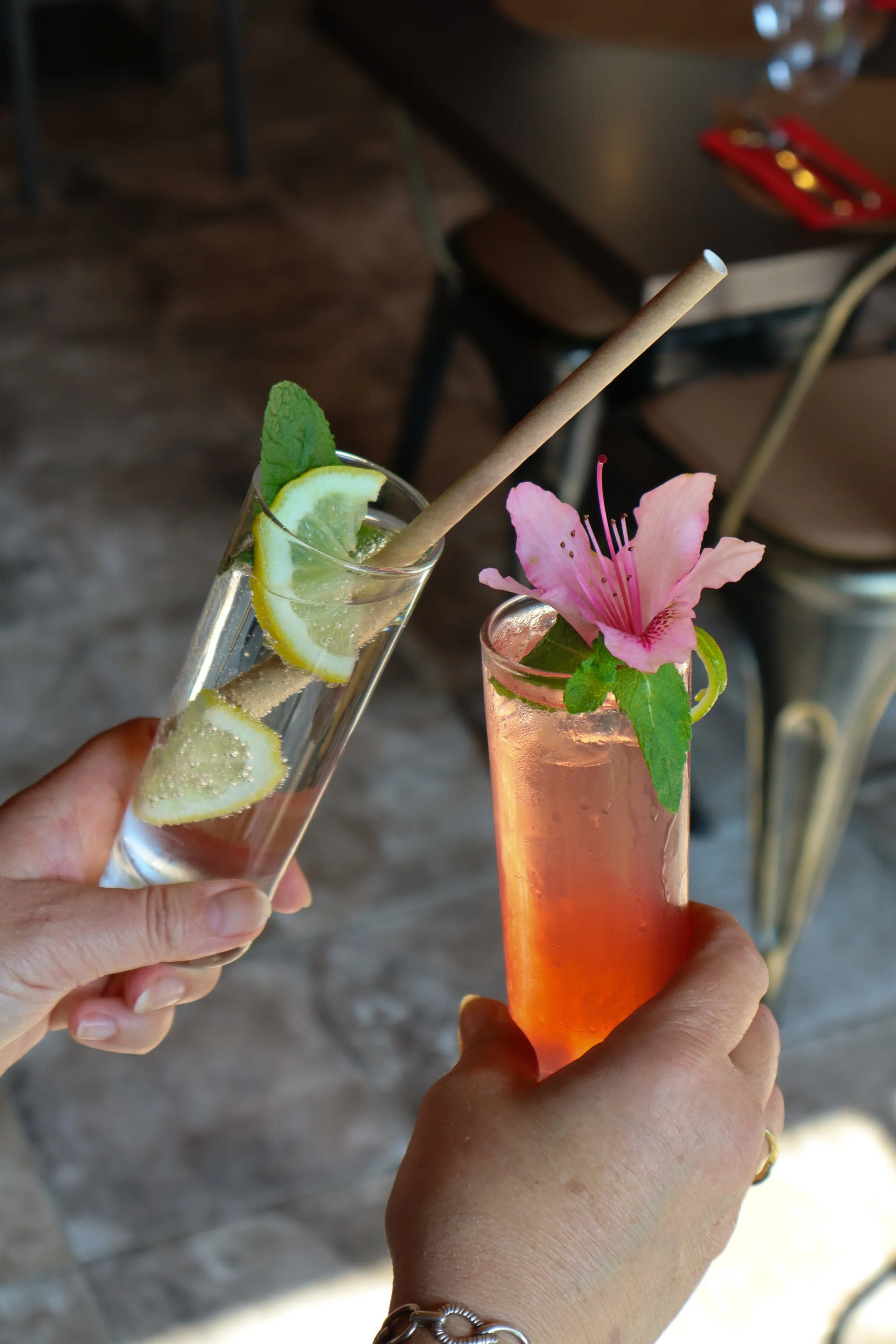 Deux cocktails colorés garnis de fruits et fleur