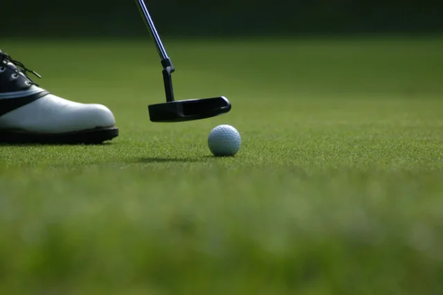 Balle de golf et putter sur le green
