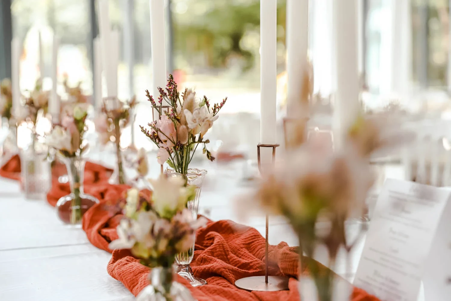 Table élégamment décorée avec fleurs et bougies blanches