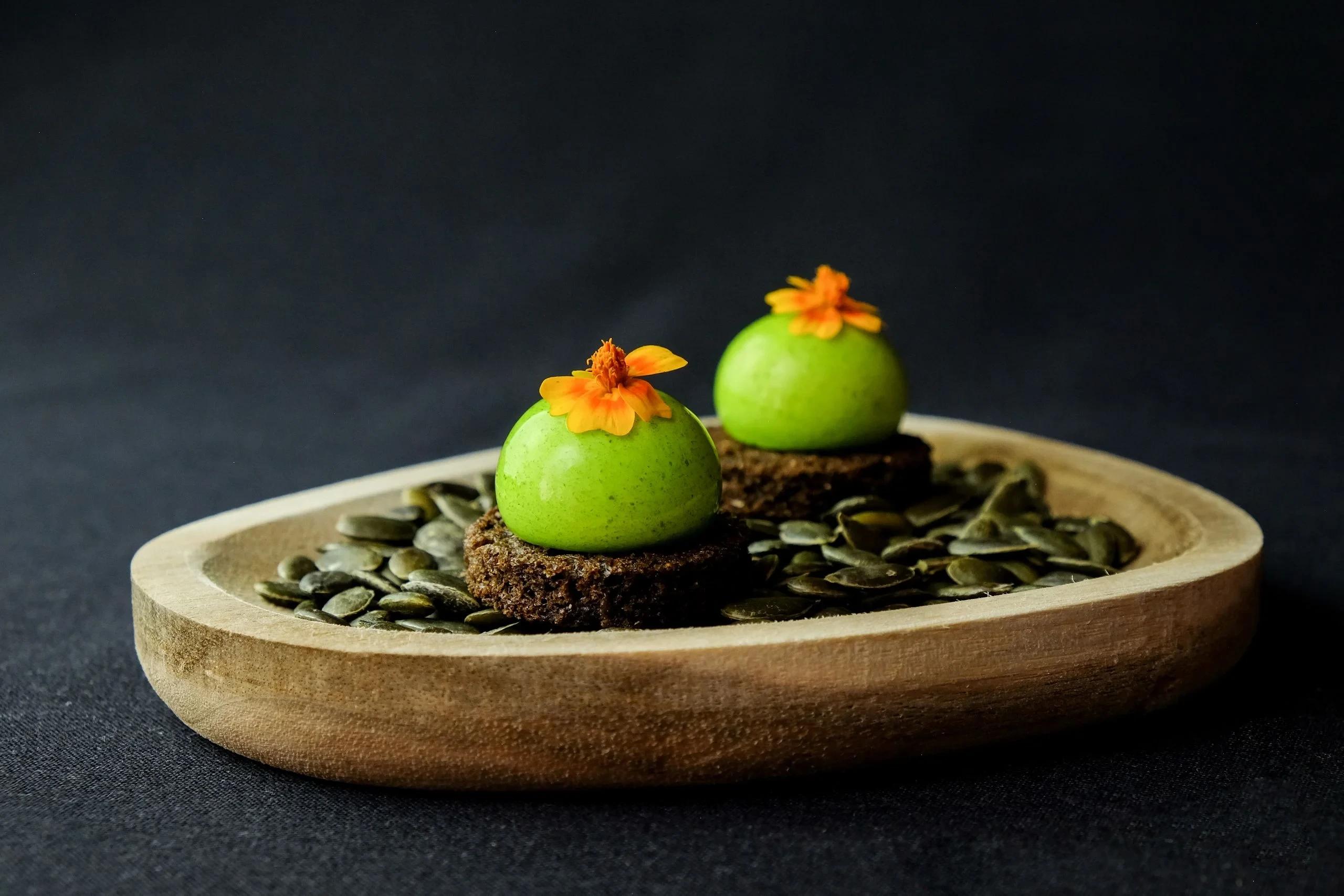 Petits entremets verts sur plateau en bois
