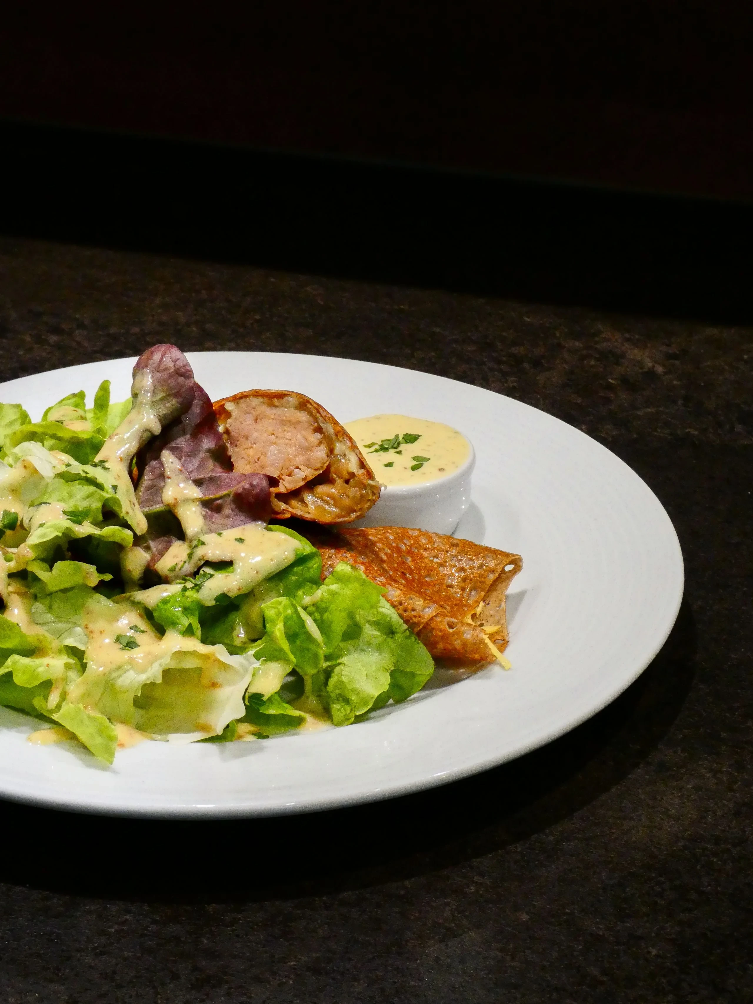 Galette garnie avec salade et sauce crémeuse