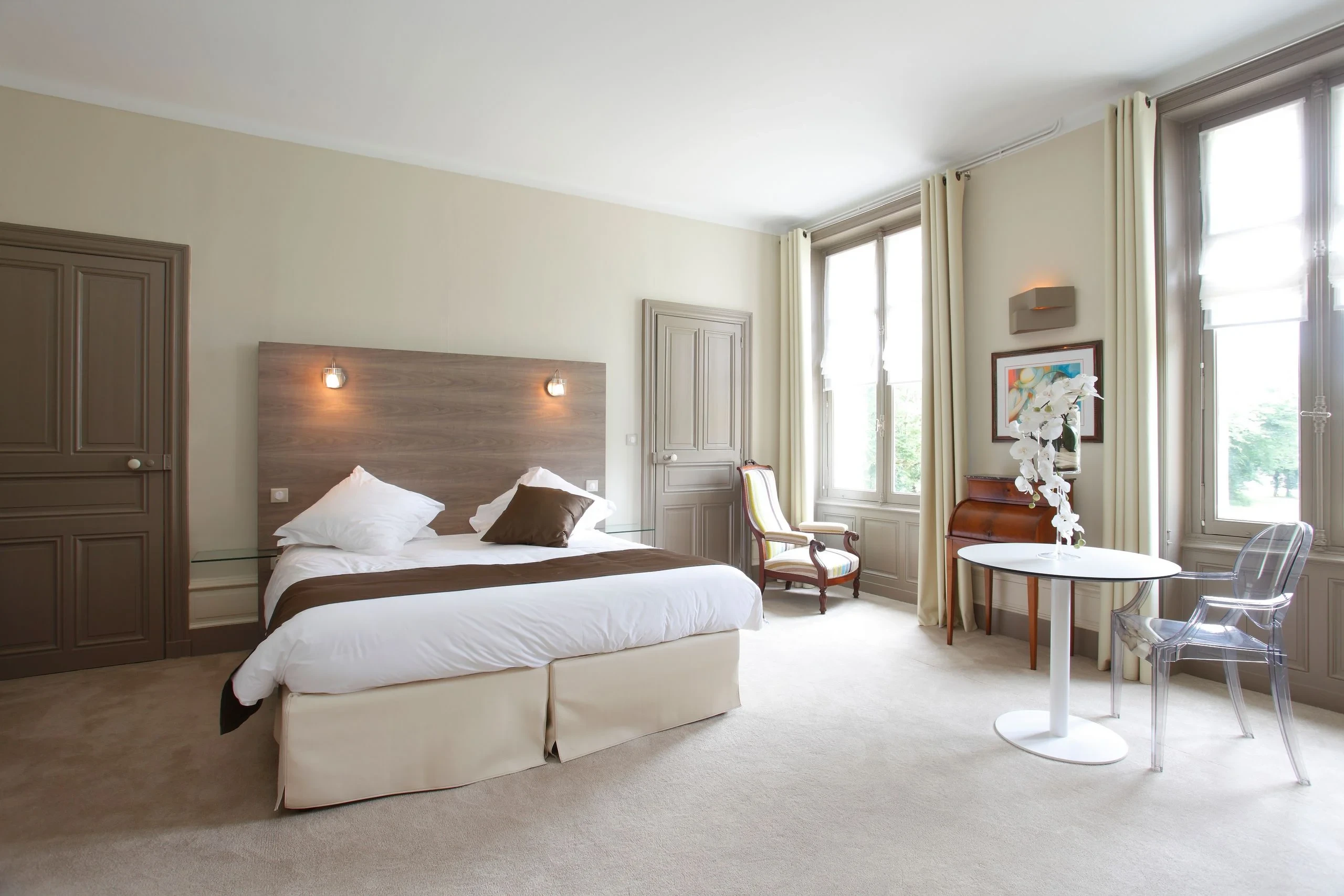 Chambre lumineuse avec lit double et grandes fenêtres
