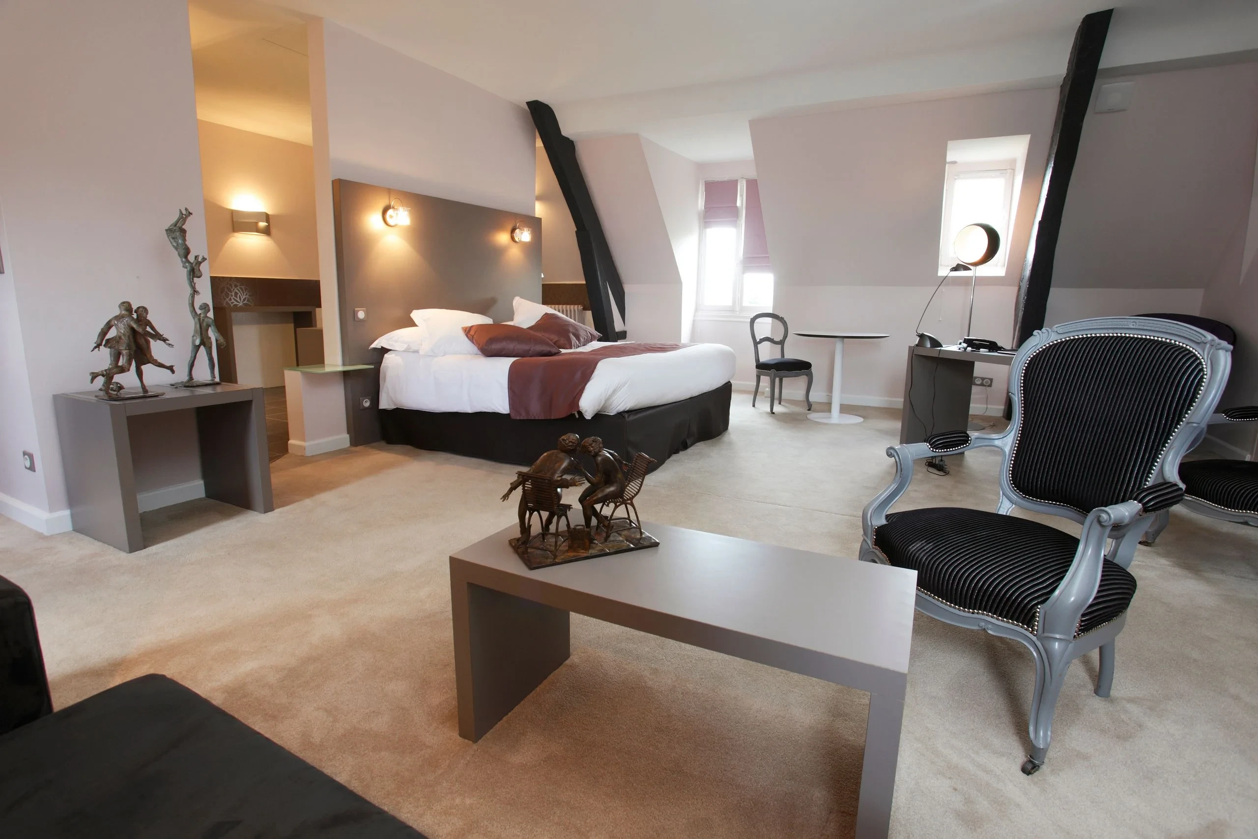 Chambre élégante avec lit double et fauteuils design